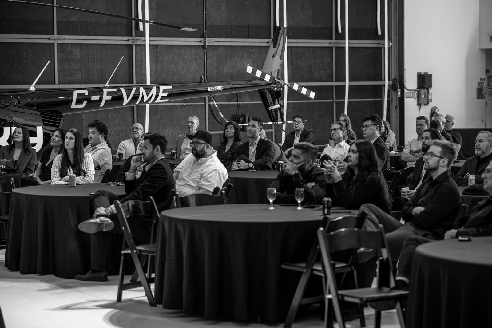 Business leaders seated at tables, listening during a Work Smarter Company session